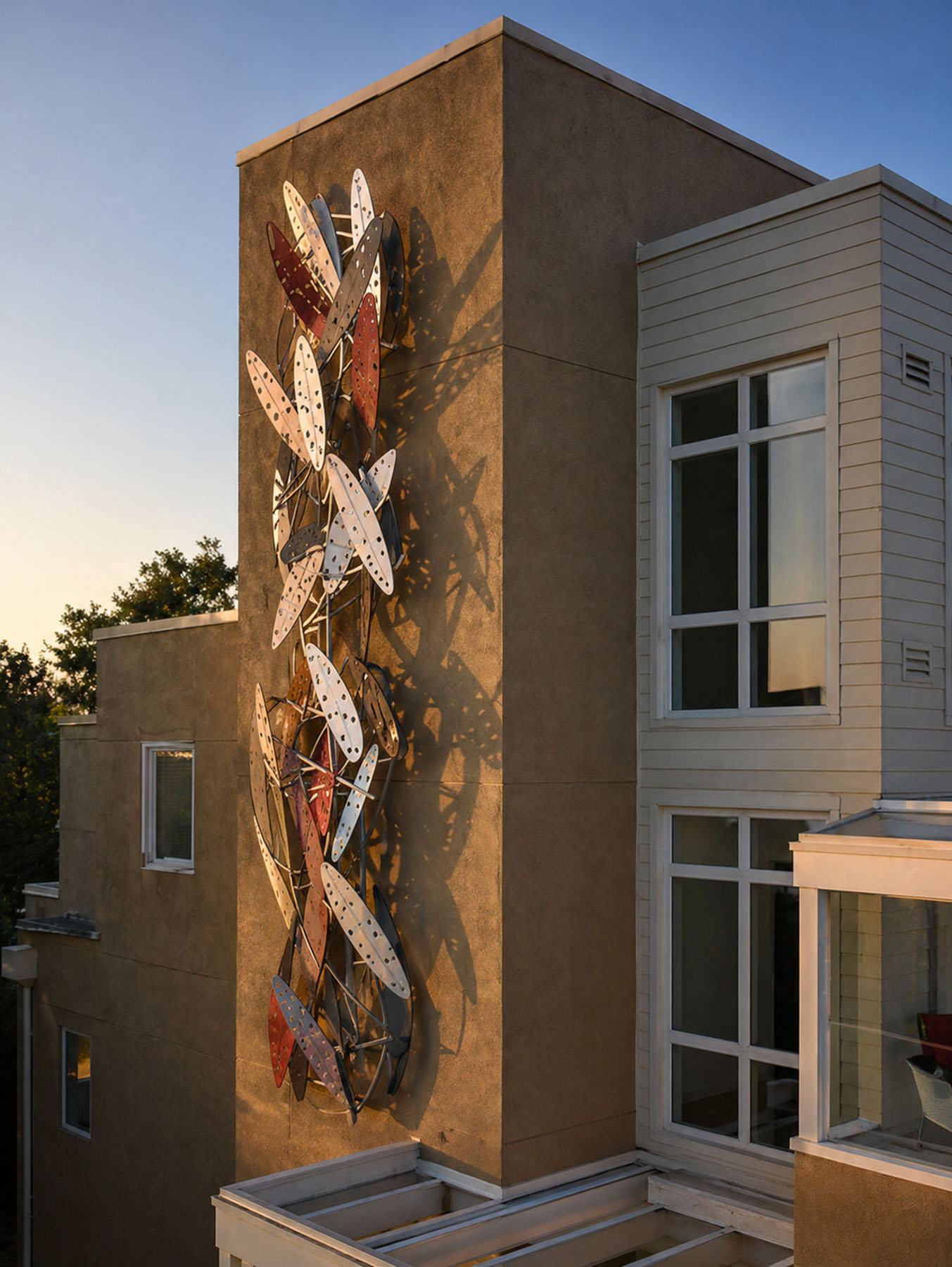 Kent Roberts, The Tree Leaf — close detail of stainless steel ellipses casting shadows on stucco at sunset